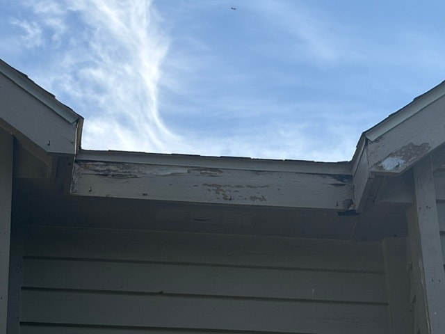 Damaged and peeling fascia boards on the roofline